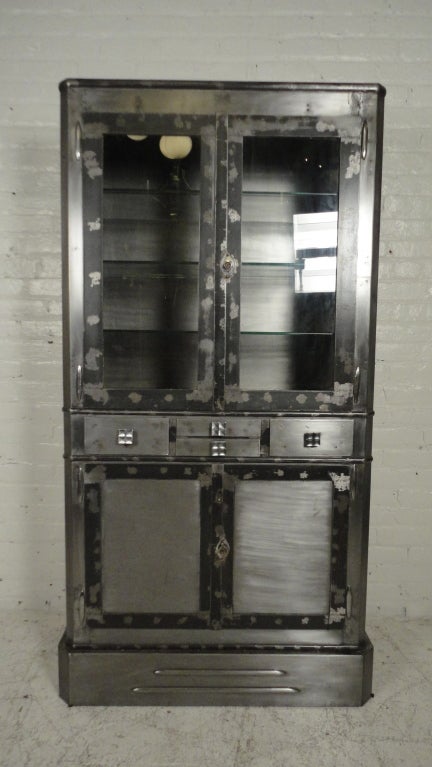 Impressive Industrial metal display cabinet with glass shelves, internal light, four drawers and storage below.