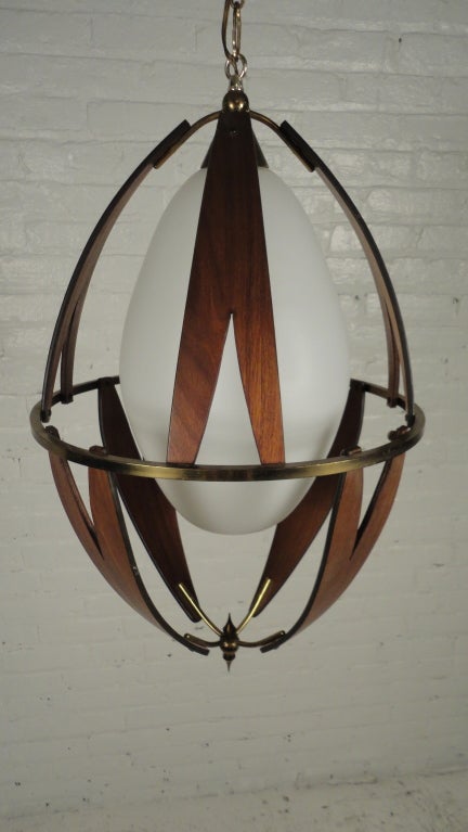 Frosted glass globe surrounded by teak & brass frame.