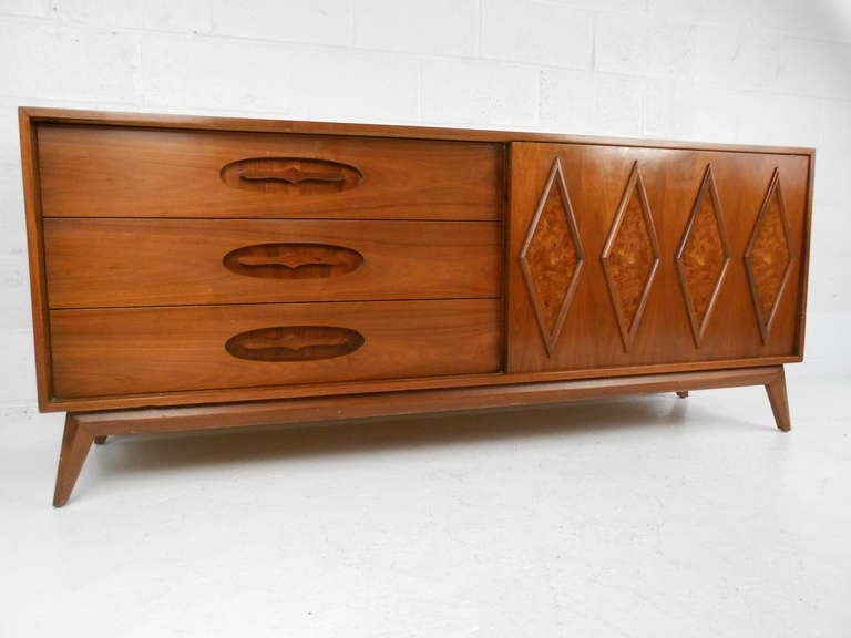 This unique Mid-Century Modern dresser features a beautifully designed sliding door with spacious drawers perfect for bedroom storage. Striking walnut finish makes an impressive vintage addition to any interior.

Please confirm item location (NY or