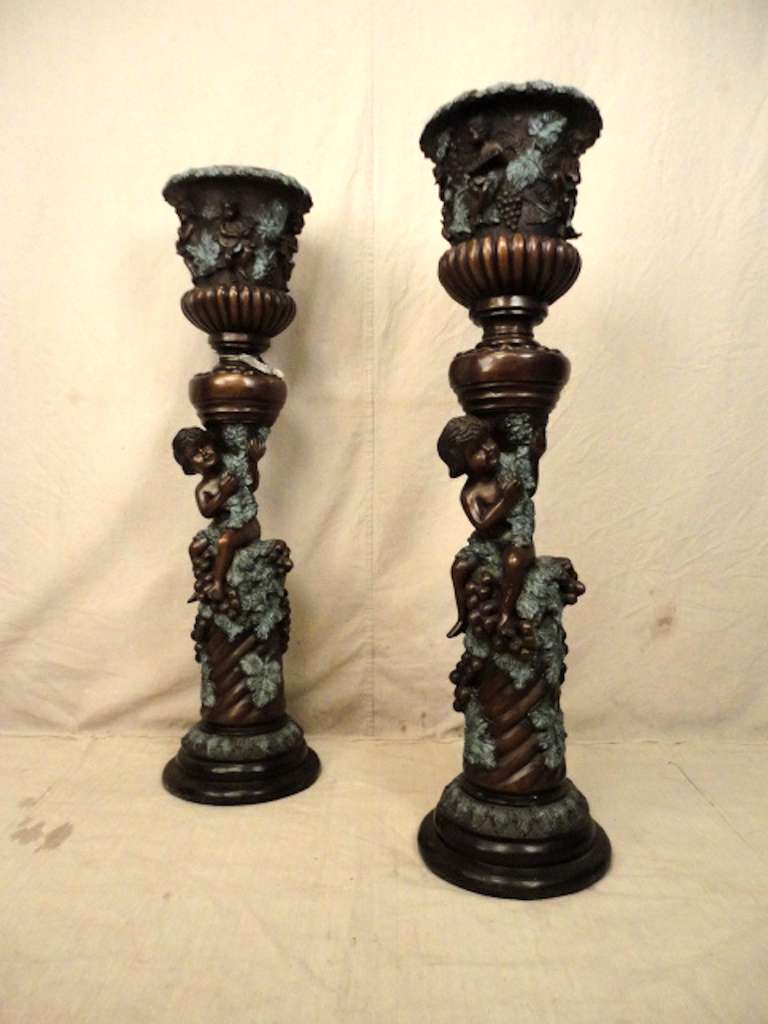 Bronze tall urns with charming detail. Lovely reliefs of cherubs in various actions and poses. Decorative garden planters.

(Please confirm item location - NY or NJ - with dealer)