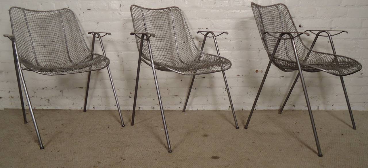 Russell Woodard designed vintage mesh wire chairs featuring thin arm rests set atop long bent iron legs. Restored and given an industrial style finish. They go great in your home or patio.

Price is for 1 chair, 3 available.

(Please confirm