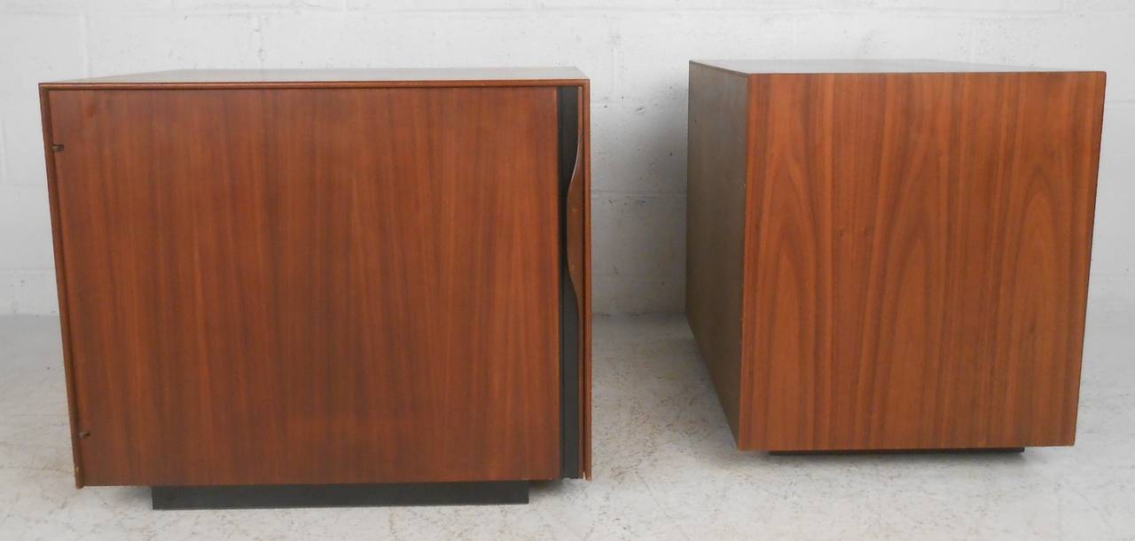 Pair of walnut nightstands designed by John Kapel for Glenn of California. Each cabinet has an adjustable shelf, magazine rack and pull-out tray. Please confirm item location (NY or NJ) with dealer.
