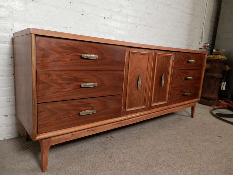 Vintage modern long dresser made of deep walnut grain with golden oak trim. Nine total drawers for plenty of storage, with original metal pulls.
Can also be used as a TV console.

(Please confirm item location - NY or NJ - with dealer)