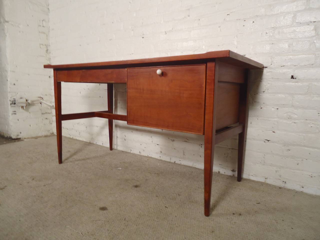 Designed by Kipp Stewart for Drexel with simple and sophisticate modern lines. Large file drawer and wide desk drawer, tapered legs, warm walnut grain. Stewart's design adds a nice sculpted lip around the edge.

(Please confirm item location - NY
