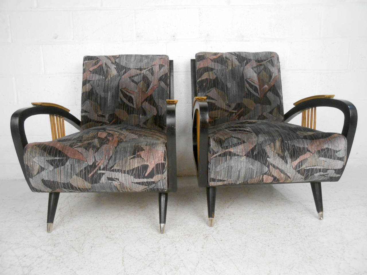 Cette paire de fauteuils de salon italiens du milieu du siècle dernier présente un cadre ébénisé, des pieds chromés et des accoudoirs uniques en forme de fuseau qui apportent une touche de modernité à la maison ou au bureau. 

Veuillez confirmer