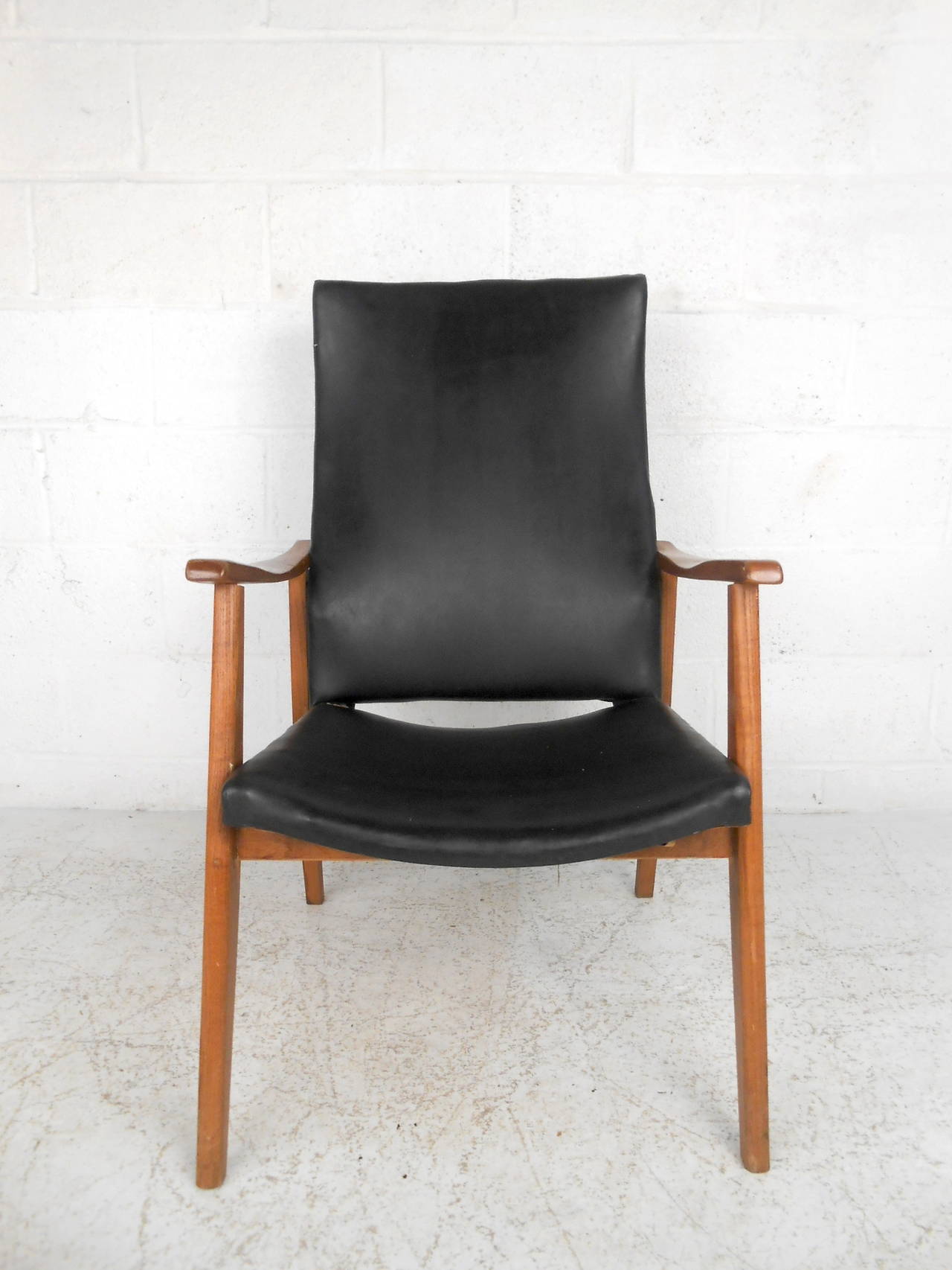 This mid century American lounge chair features a solid walnut frame and black vinyl upholstered seat which offers a subtle modern style to any home or office space.  

Please confirm item location (NY or NJ) with dealer.