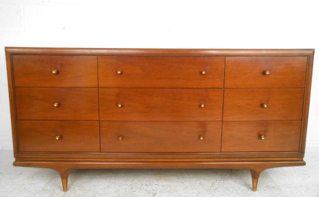 This unique mid-century dresser features wonderful vintage brass trim accenting a stylish nine drawer design. Matching bedroom set available (two highboys, nightstands, and bed), please confirm item location (NY or NJ).