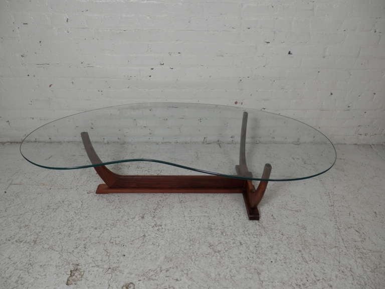 This completely retro table has a classic 'kidney' shape glass top that sits on a tapered wood base. Very much in the style of master designer Adrian Pearsall.

(Please confirm item location - NY or NJ - with dealer)