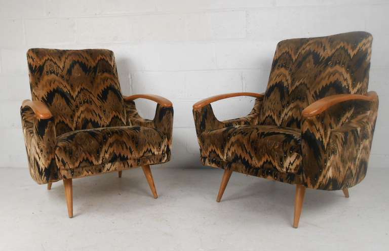 Great pair of stylish lounge chairs with sculptural wood arms, flared legs and dramatic tufted-back upholstery. Unique mid-century modern shape makes an  impressive addition to any interior. Please confirm item location (NY or NJ) with dealer.