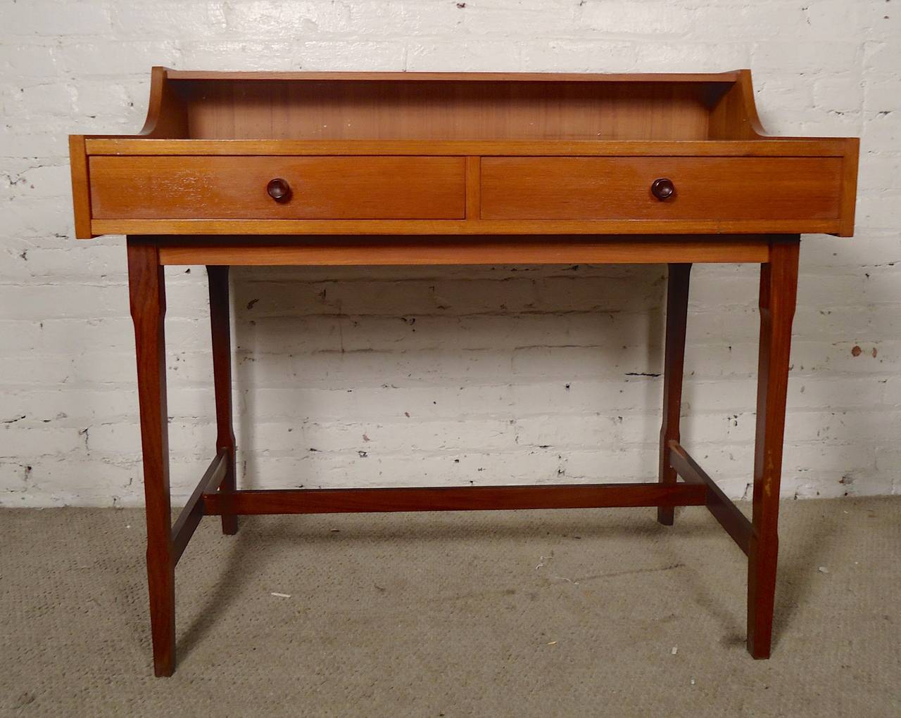 Miniature teak desk with finished back. Lovely teak grain throughout, deep rosewood handles, top shelf, two drawers. Great for a small apartment.

(Please confirm item location - NY or NJ - with dealer)