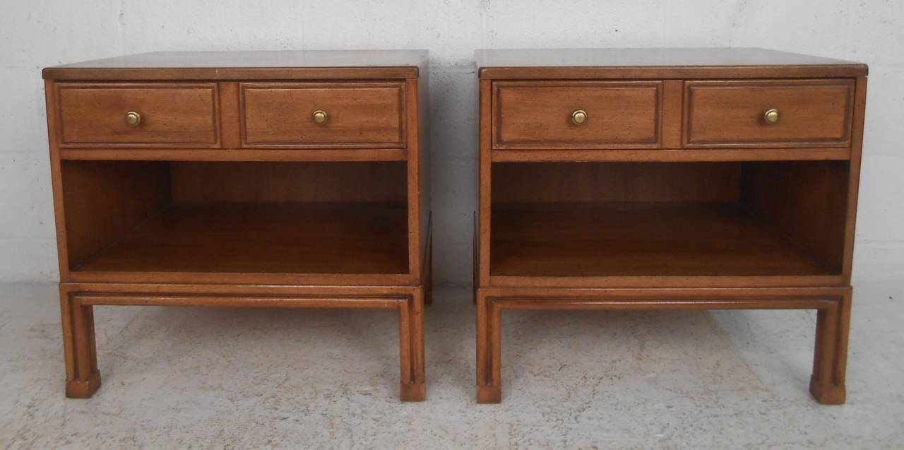 Pair of vintage modern mahogany nightstands by Davis Cabinet Co. feature dovetailed drawer storage, unique sculpted legs, and spacious open storage shelf. Unique dimensions allow for plenty of bedside storage space, please confirm item location (NY