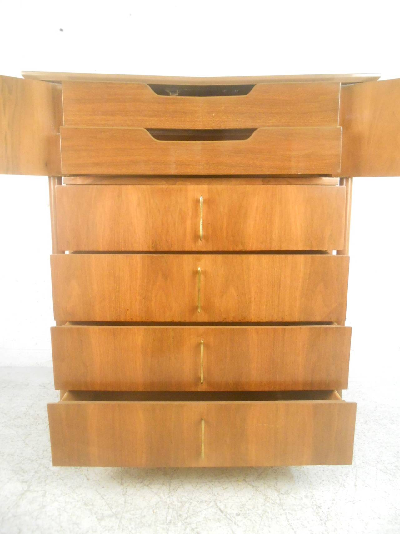 This wonderful highboy dresser features stylish vintage drawer and cabinet pulls as well as unique sculpted legs. This fantastic dresser is a beautiful addition to any room and offers plenty of storage space for any interior. Please confirm item