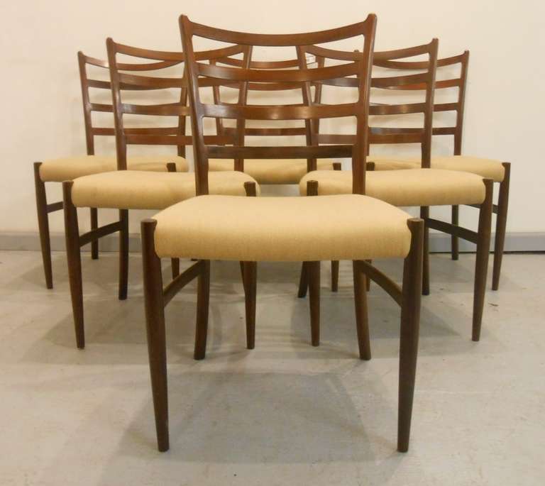 Set of six Scandinavian modern ladder back dining chairs in the style of Arne Vodder. Impressive sculptural seat backs, plush and comfortable seats, and simple mid-century style make these Danish modern chairs an elegant addition to any dining room.