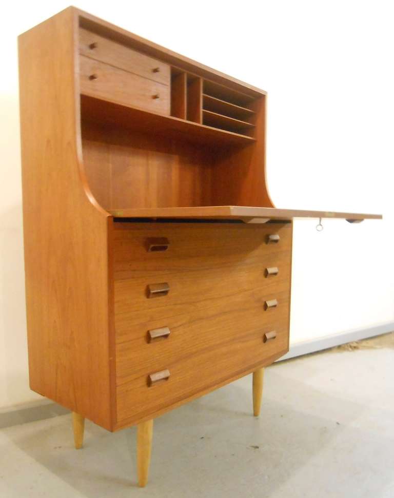 A beautifully detailed teak bureau by legendary designer Borge Mogensen. The fold-down front reveals a writing surface, two drawers and assorted storage slots. Manufactured by Soborg Mobelfabrik. Please confirm item location (NY or NJ) with dealer.