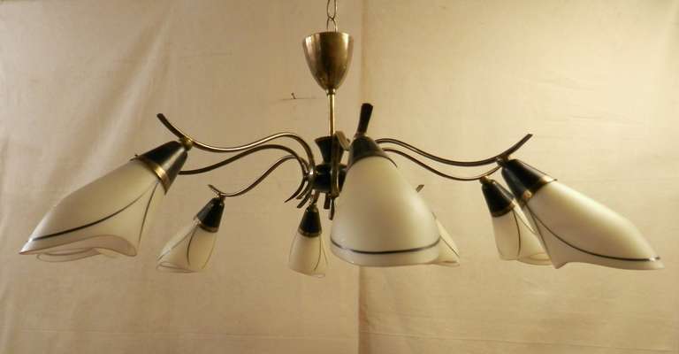 Stunning eight shade Mid-Century chandelier. There are S-curved brass arms tipped with scooped form frosted glass shades with decorative enamel trim.

(Please confirm item location - NY or NJ - with dealer).