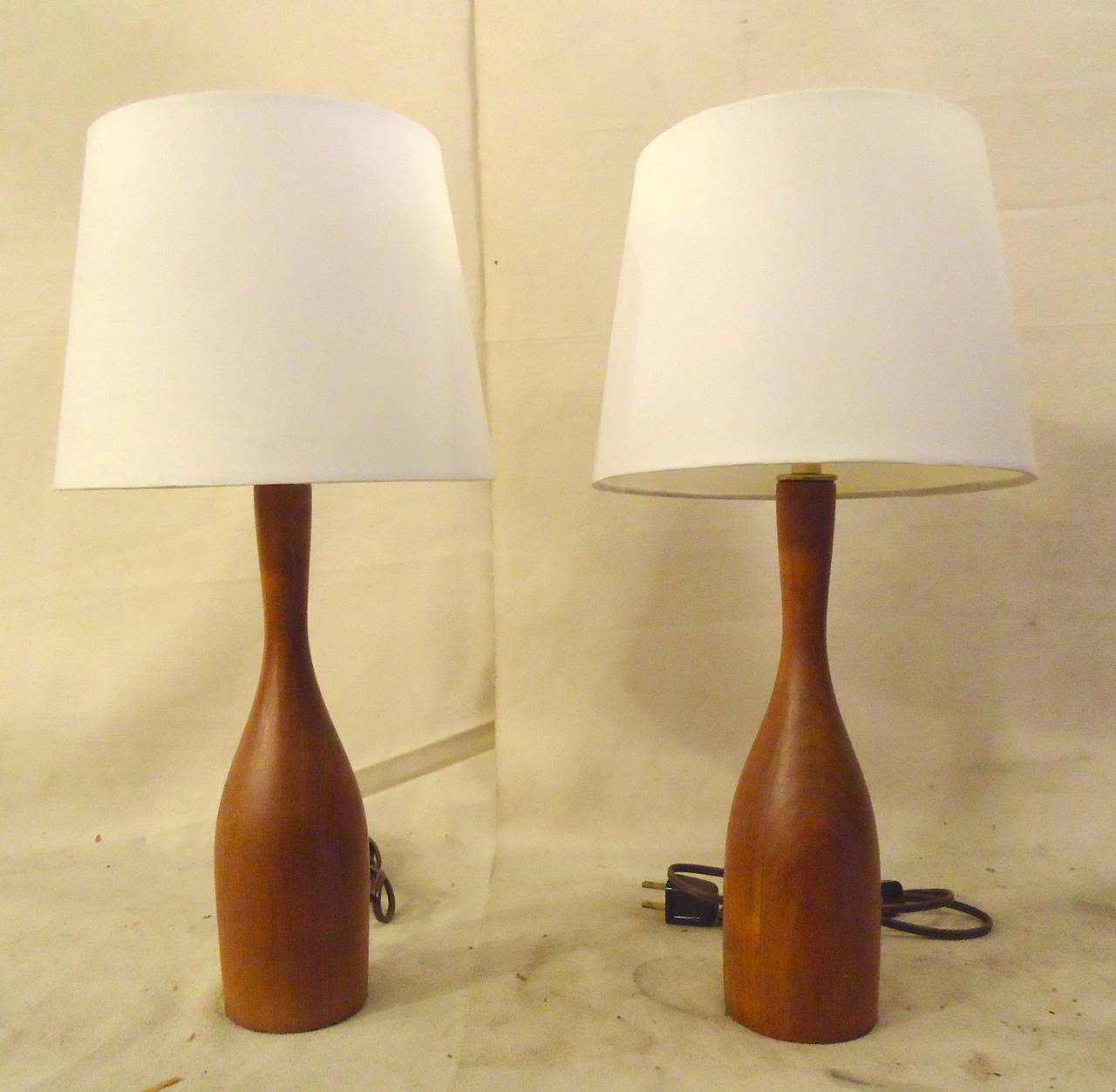 Beautiful mid-century lamps with smooth bottle form. Solid teak petite table lamps in the style of ESA.

(Please confirm item location - NY or NJ - with dealer)
