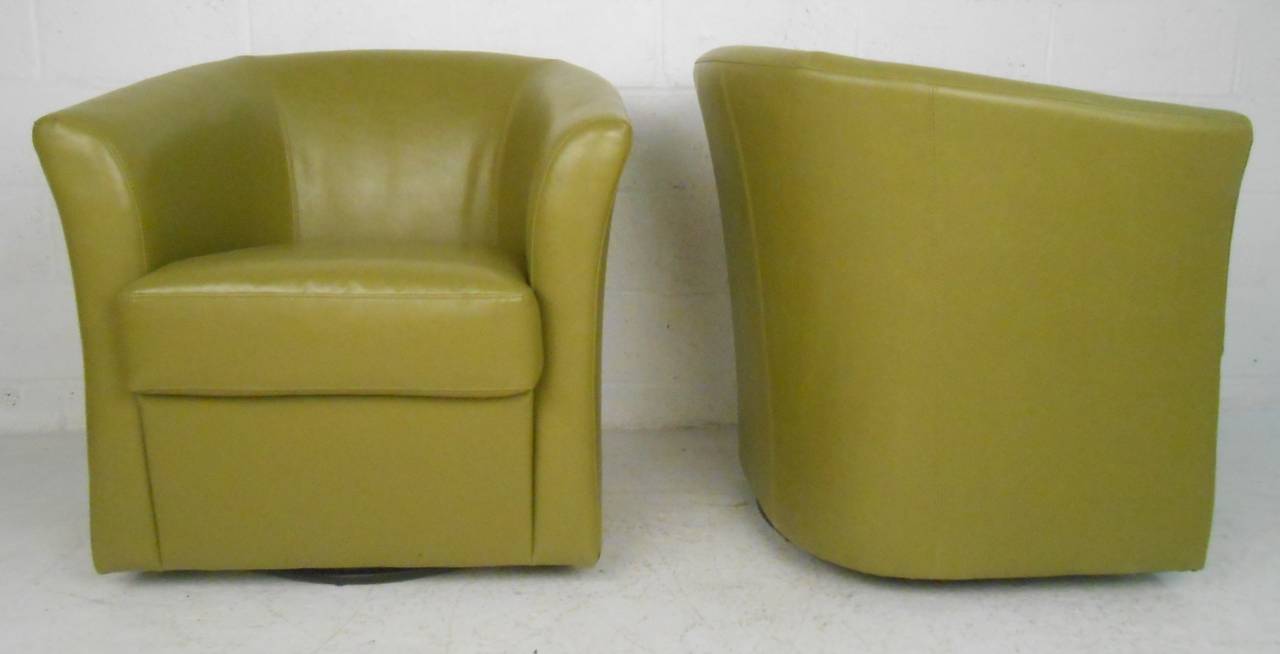 Two modern round back club chairs with olive-green vinyl upholstery set on chrome swivel base. Deep, comfortable barrel chairs, great for office or home.

(Please confirm item location - NY or NJ - with dealer)