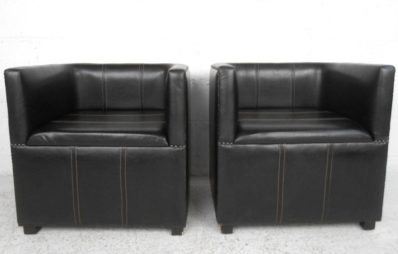 This pair of leather club chairs features a unique squared shape with studded upholstery makes for a wonderful combination of style and comfort. Please confirm item location (NY or NJ).