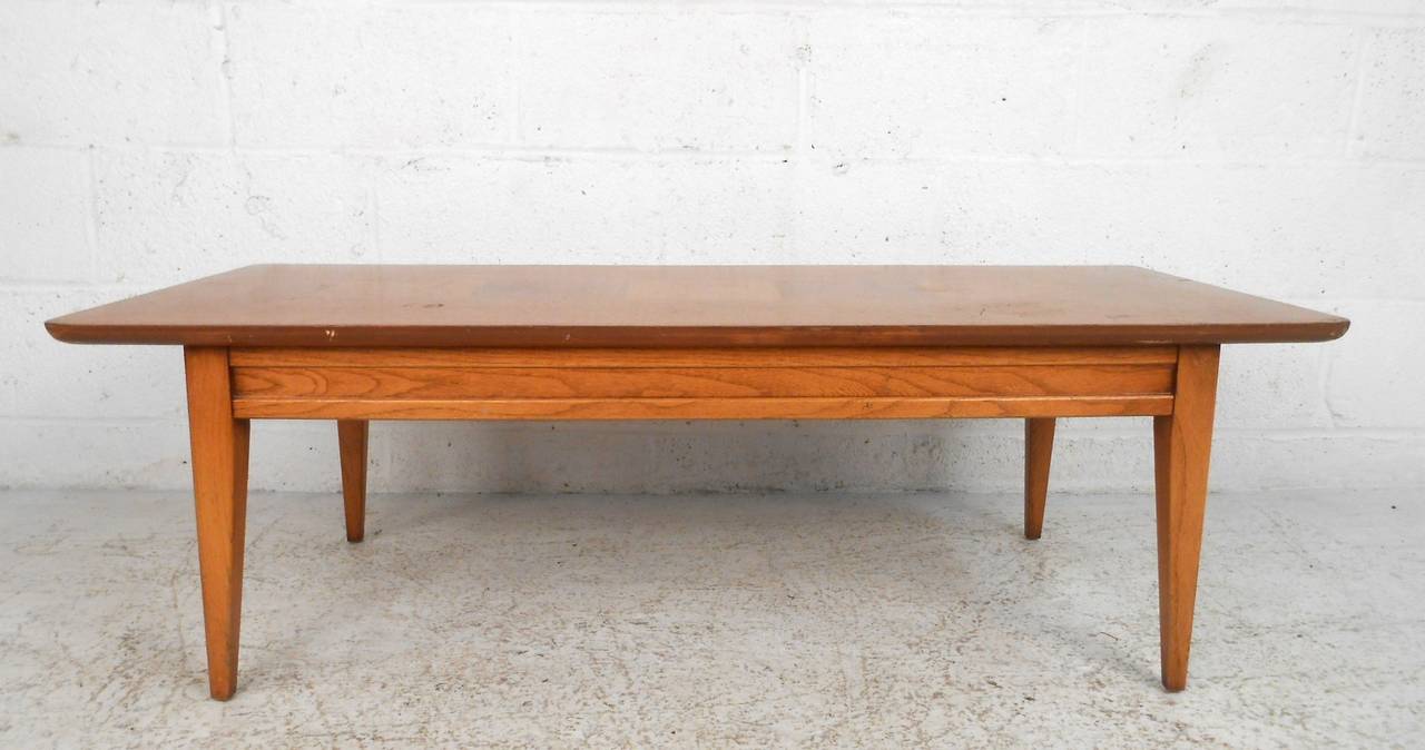 This simple yet stylish coffee table by Lane features classic midcentury design coupled with sturdy construction. Unique burl wood inlay makes this piece a unique addition to any home. Please confirm item location (NY or NJ).