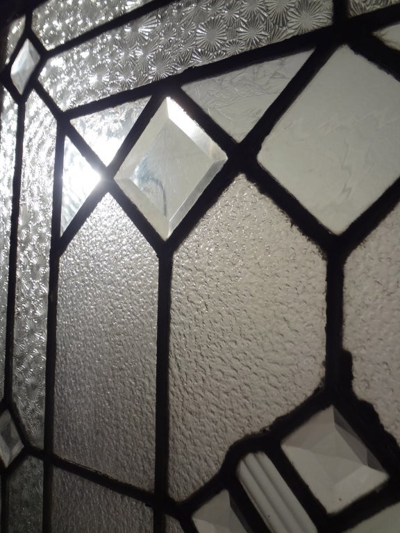Early 20th century leaded glass window comprised of clear beveled and textured glass.