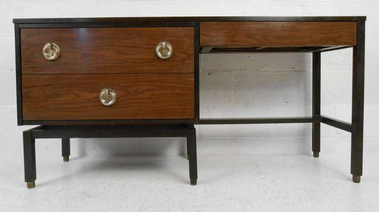 This stylish mid-century writing desk features design by Edward Wormley for Dunbar Furniture. Two tone finish accented by unique metal drawer pulls. Perfect three drawer desk for home or business office. Please confirm item location (NY or NJ) with