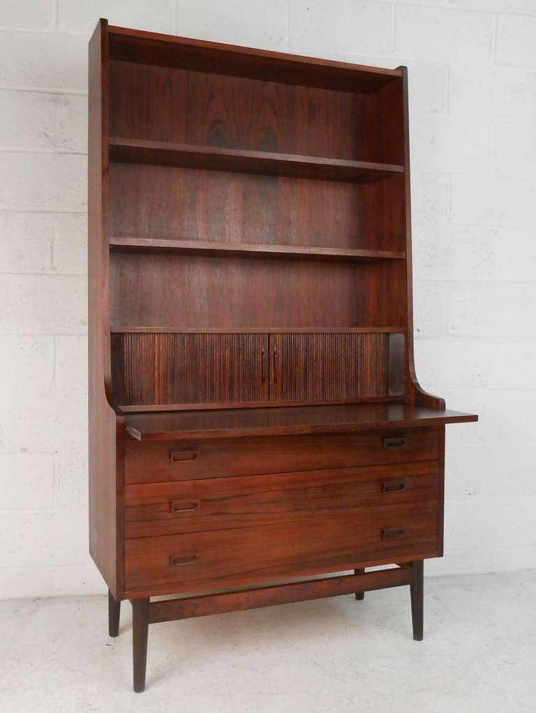 Beautifully designed rosewood cabinet manufactured in Denmark by Bornholm Mobler, circa 1960s. Top has a slide out writing surface and tambour doors concealing three drawers and storage spaces. Lower cabinet consists of three storage drawers. Please