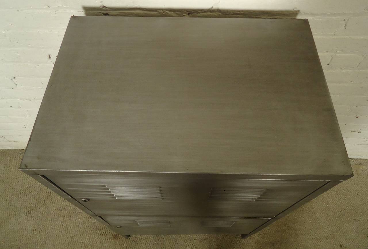 Metal cabinet, features two doors revealing one shelf on top and additional brackets for extra shelf on bottom. Restored in a bare metal style finish.

(Please confirm item location - NY or NJ - with dealer).