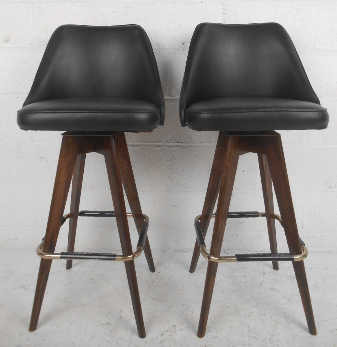Pair of stylish black vinyl swivel bar stools. Please confirm item location (NY or NJ) with dealer.