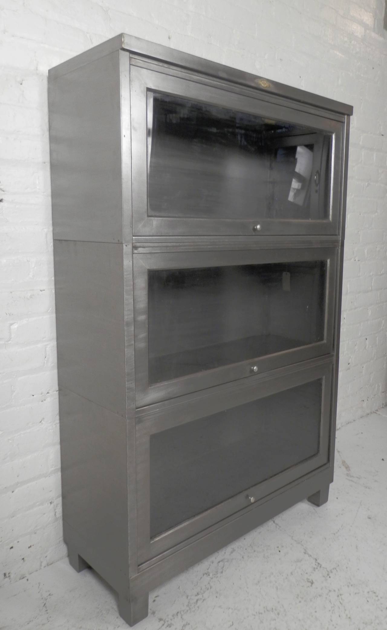 Vintage lawyers stack bookcase, refinished in a bare metal style. Three glass front cabinets that recede into the unit. Originally used by lawyers to protect their law books, now restored for your modern home.

(Please confirm item location - NY