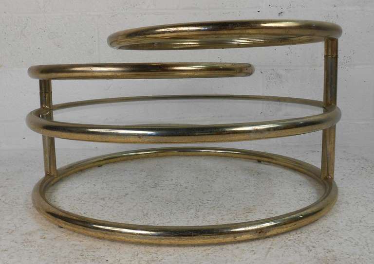 Three-tier extendable brass and glass cocktail table.