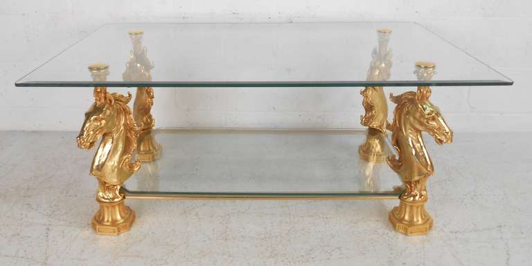 Unique two level glass table with finely detailed horse head supports. Signed 