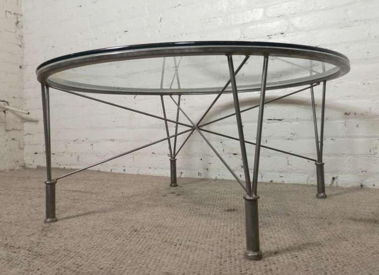 Industrial metal base with crossing metal rods that create stability and attractive flair. Round glass sits atop.

(Please confirm item location - NY or NJ - with dealer)