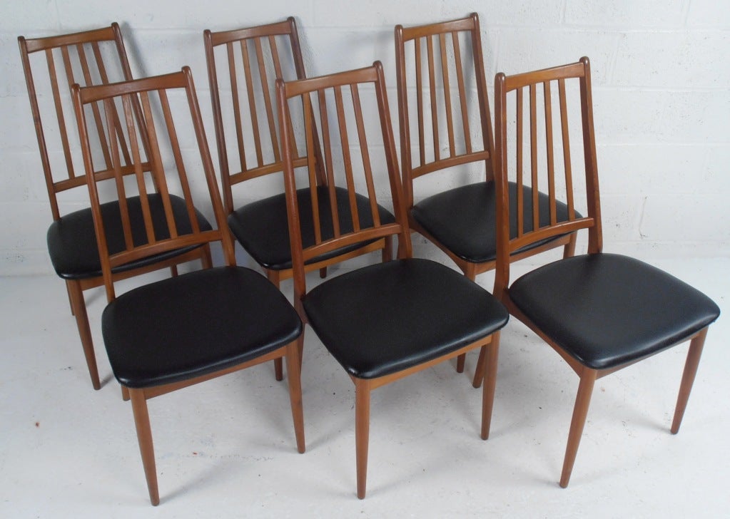 This set of six Scandinavian Modern dining chairs feature quality teak construction with black vinyl seats. Excellent set of six dining chairs make a perfect mid-century to any dining room set. Please confirm item location (NY or NJ).