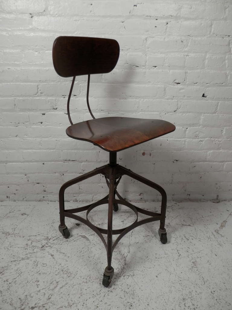 Bentwood seat and back rest on a metal frame. Industrial chair has a swiveling seat with adjustable height and classic Toledo chair company styling on rolling casters. Stamped with the Toledo factory stamp.

(Please confirm item location - NY or