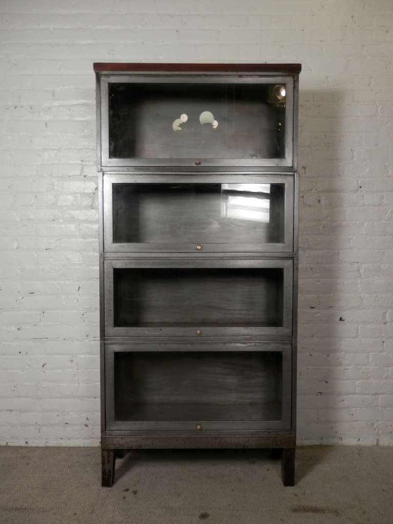 Factory style stack-able barrister bookcase, restored in a bare metal industrial look, completed with a finished wood top. All glass doors open and recess into the top, then close leaving items free from dust. Includes original brass