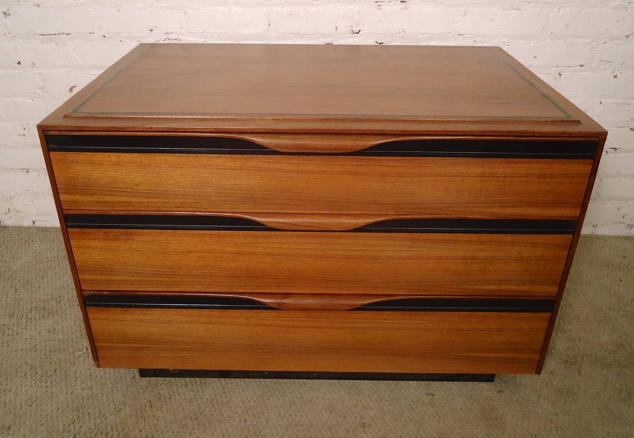 Mid-century modern bedside dresser for John Stuart designed with beautiful walnut grain, black trim and sculpted handles. Makes a great bedside dresser or small TV console.

(Please confirm item location - NY or NJ - with dealer)