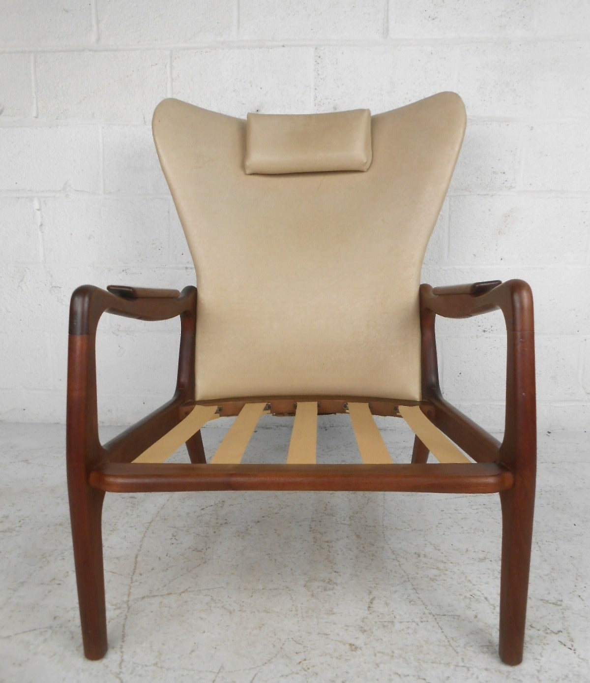 This beautiful midcentury lounge chair features the iconic design of Adrian Pearsall. Sculpted armrests and wingback seating make this a comfortable and uniquely stylish addition to any room. Vintage vinyl upholstery intact, including removable