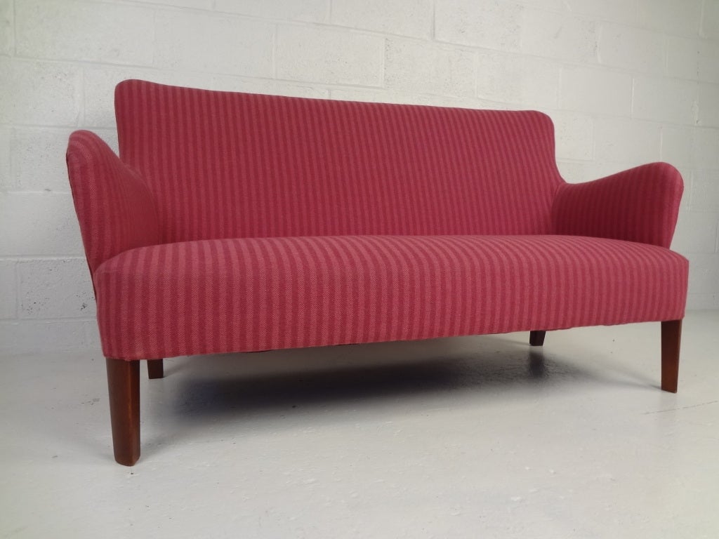 Simple and elegant sculptural sofa in the style of Finn Juhl.