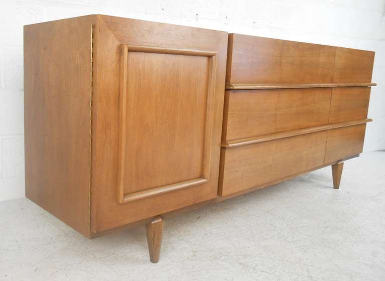 Beautiful, mid-century walnut dresser by American of Martinsville featuring six drawers and hinged door with three trays. Please confirm item location (NY or NJ) with dealer.