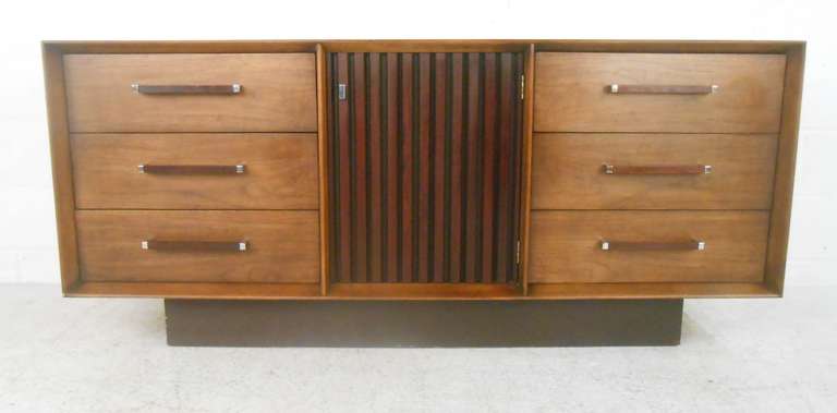 This stylish mid-century walnut dresser features unique rosewood pulls, six drawers, and center cabinet with three trays. Vintage walnut construction, unique inlaid details, and spacious storage set this Lane Furniture dresser apart. Please confirm