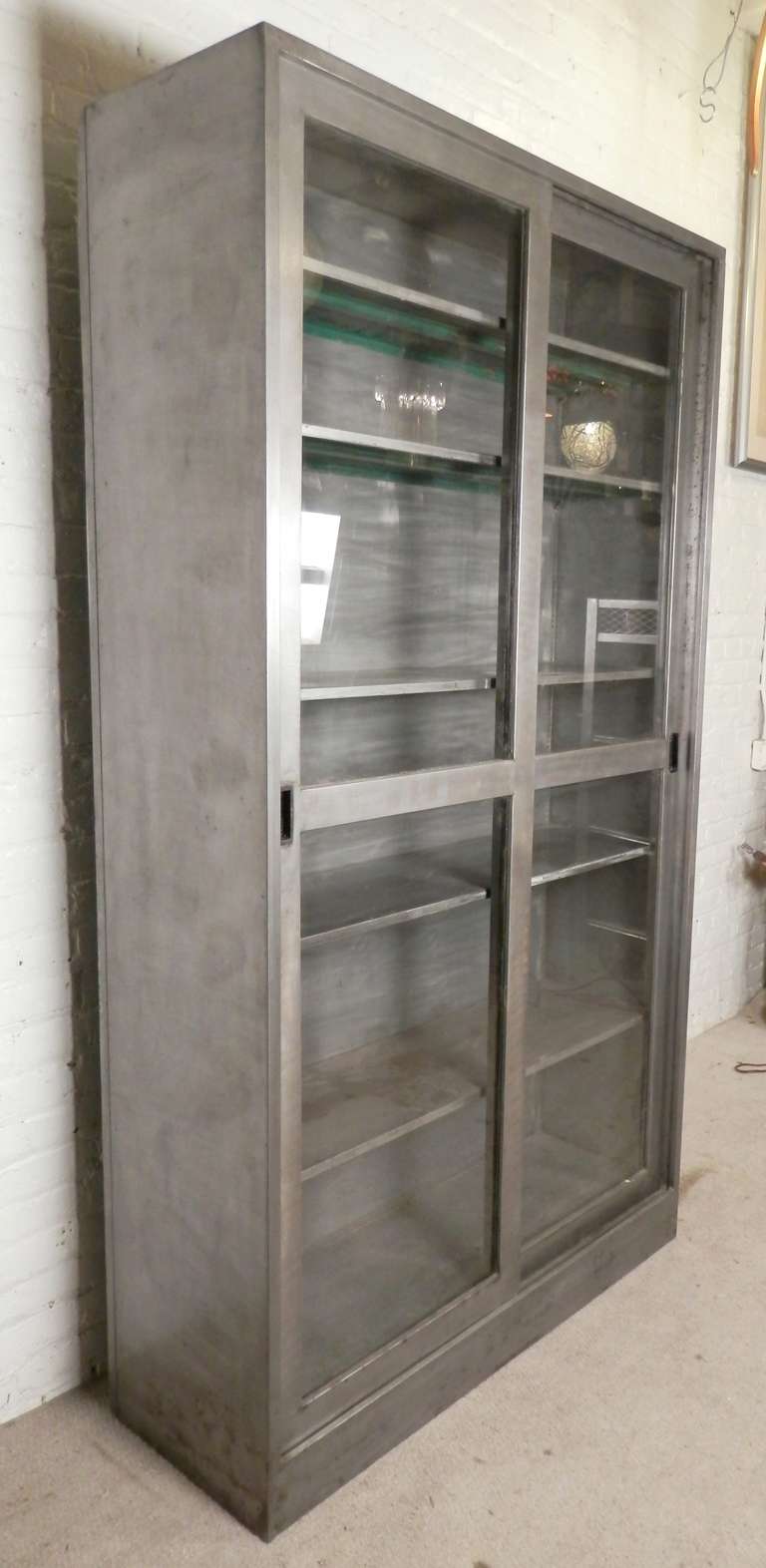 Over-sized factory cabinet with large sliding glass doors. Comes with five metal shelves, fully adjustable up and down the cabinet.

(Please confirm item location - NY or NJ - with dealer)