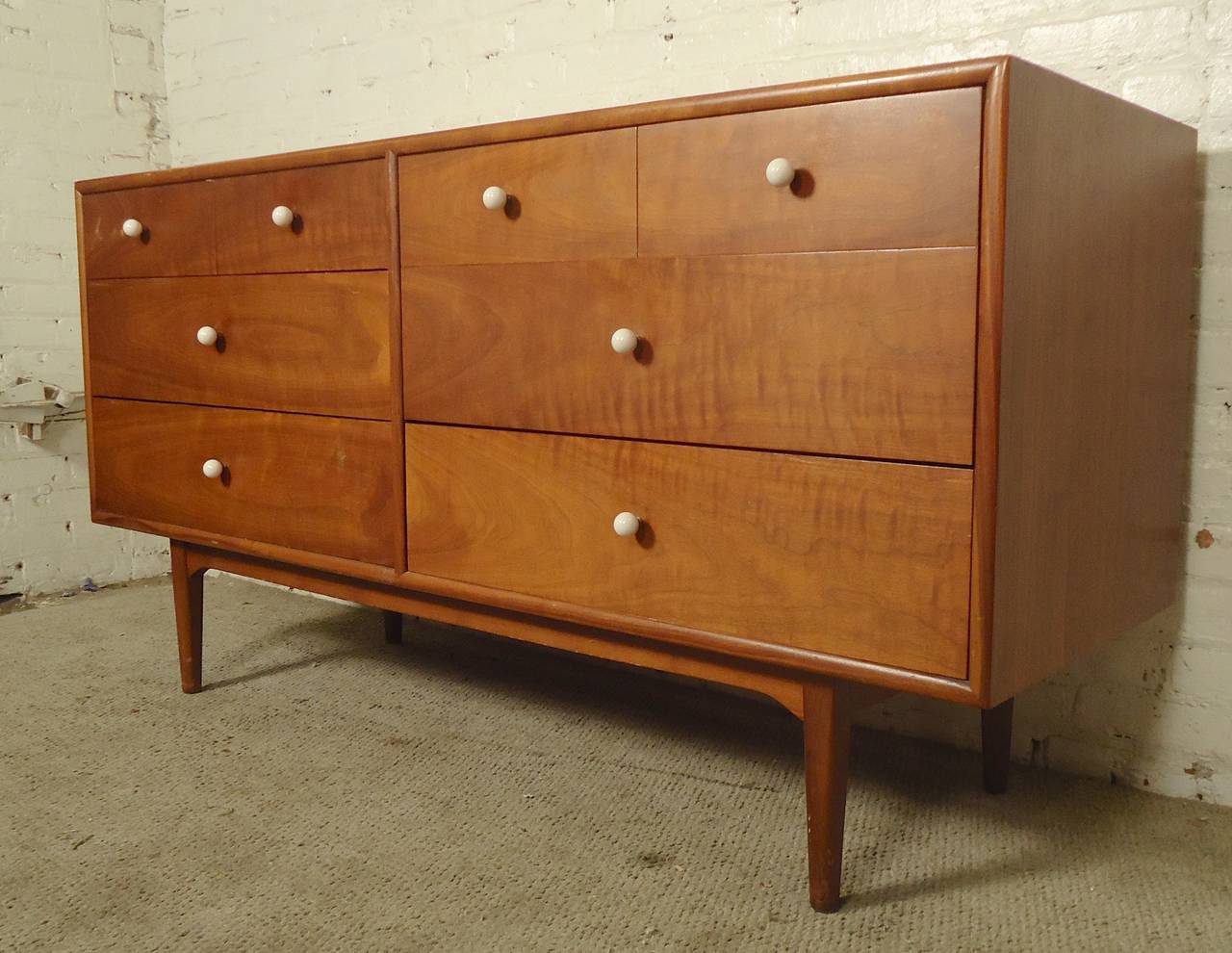 Attractive mid-century modern eight drawer dresser with walnut grain, accented with milk white glass handles. Great design and function.

(Please confirm item location - NY or NJ - with dealer)