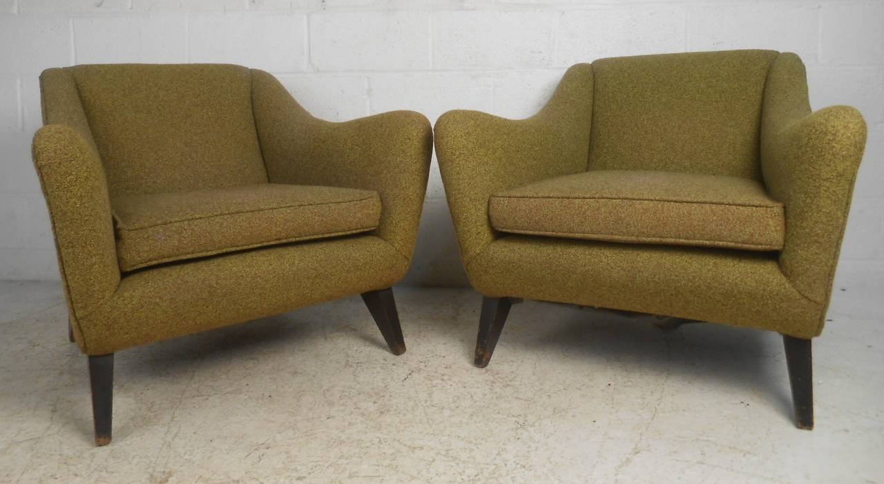 Stylish pair of low lounge chairs feature Scandinavian Modern design and comfortable upholstered seats. Perfect pair of midcentury club chairs for home living room or office lounge. Please confirm item location (NY or NJ) with dealer.