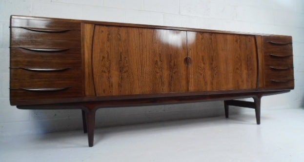 Rosewood credenza/server by Johannes Andersen featuring tambour doors in the center and four felt lined drawers on each side.