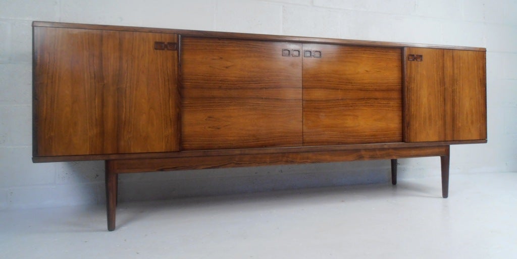 Rosewood server with recessed pulls, adjustable shelves & four felt lined storage drawers.