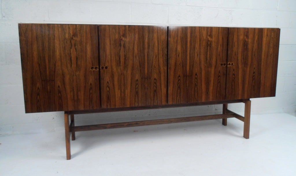The large-scale and impressive Rosewood finish on this vintage modern server make it the visual centerpiece of any setting. Kai Kristiansen attributed design combines Scandinavian Modern simplicity with elegant versatility, offering plenty of