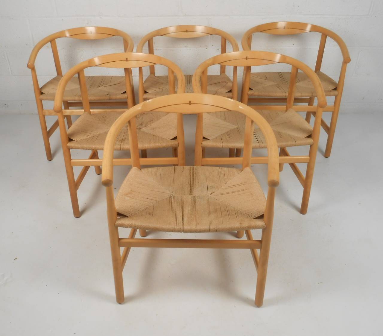 Set of six armchairs designed by Hans. J. Wegner in 1969 and produced by PP Mobler. Constructed in ash, featuring wenge inlay and paper cord weave seats. Please confirm item location (NY or NJ) with dealer.