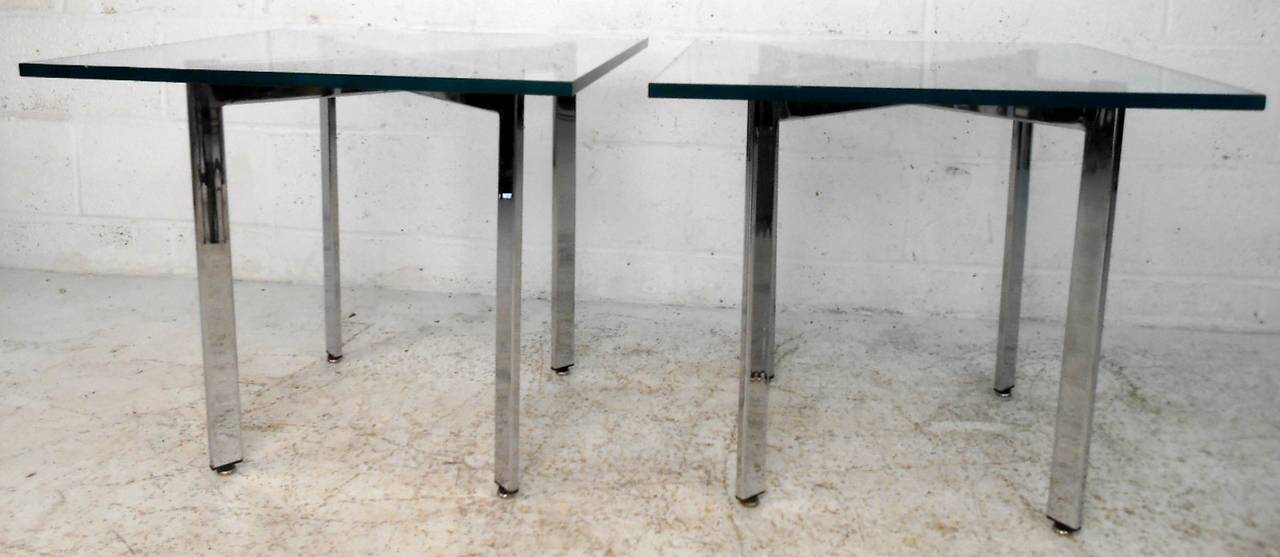 Two vintage-modern side tables featuring sculpted chrome x-bases and square glass table tops. In the manner of Milo Baughman.

(Please confirm item location - NY or NJ - with dealer)