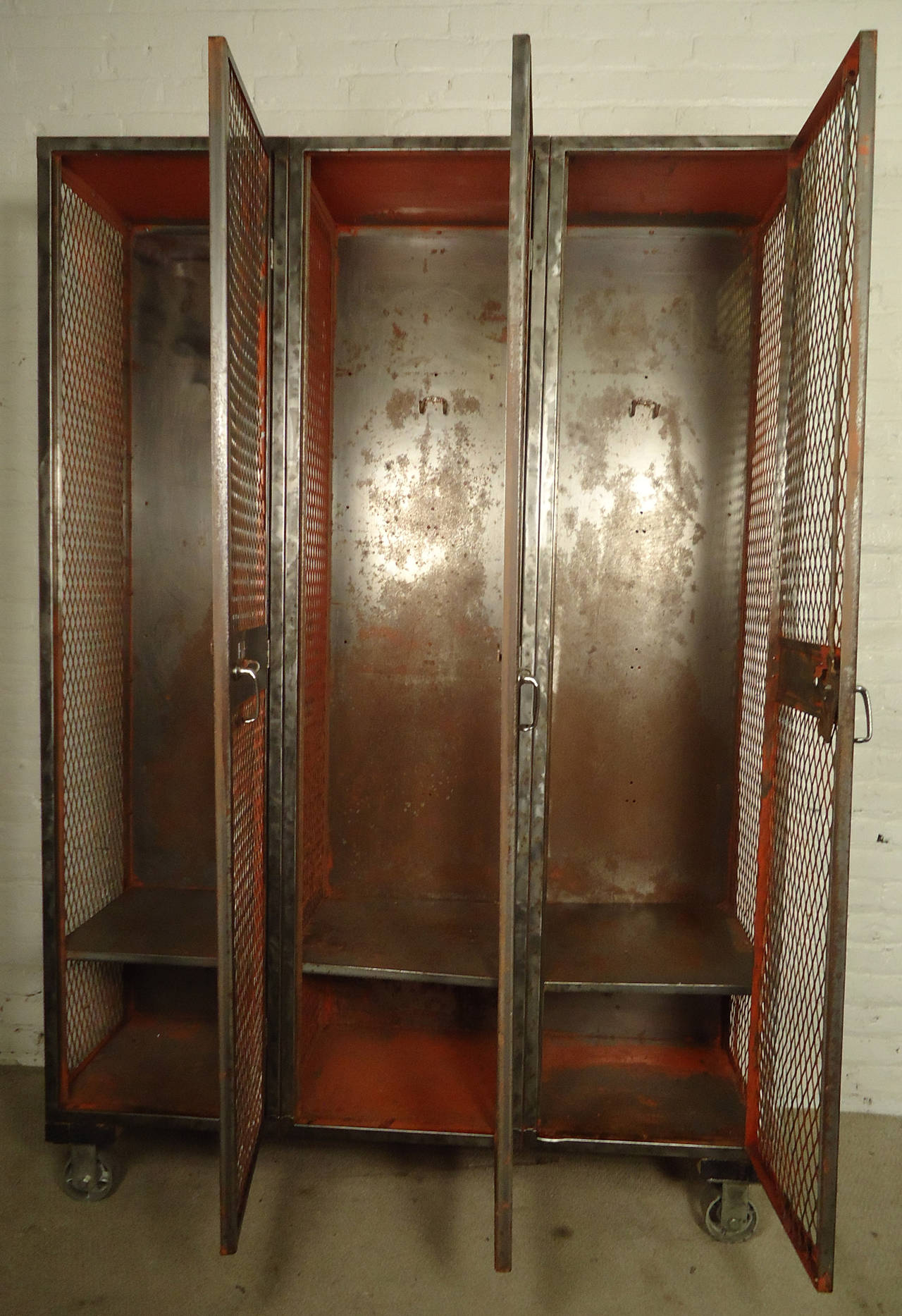 Large mesh front Industrial metal locker unit featuring three units each with coat hooks and lower storage, all on large metal castors.

(Please confirm item location - NY or NJ - with dealer).