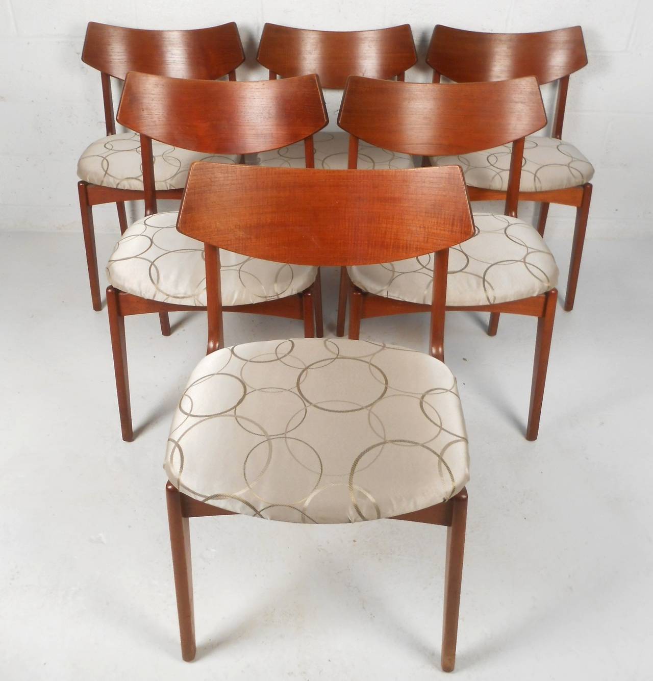 This set of six mid-century chairs make a comfortable and unique addition to any dining room. By Erik Buch for Funder-Scmidt & Madsen, the set offers Comfortable curved back design along with wide seats and wonderful teak finish. Please confirm item